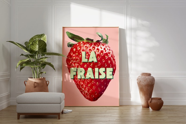 K&ouml;nnte beinhalten: Ein rosa Poster mit einer gro&szlig;en roten Erdbeere und dem Text "LA FRAISE" in gr&uuml;nen Buchstaben.