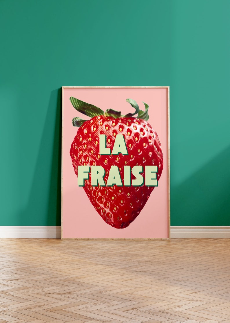 K&ouml;nnte beinhalten: Ein rosa Poster mit einer gro&szlig;en roten Erdbeere und dem Text "LA FRAISE" in gr&uuml;nen Buchstaben.