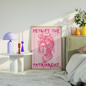May include: A pink and white poster with the text "Petrify the Patriarchy" and a pink illustration of a woman's head with snakes in her hair.