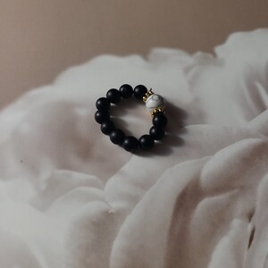 Ring met zwarte, marmeren en goudkleurige kralen