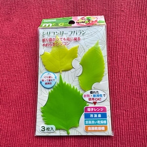 Peut inclure: Un paquet de trois séparateurs alimentaires en silicone en forme de feuilles, verts et jaunes. L'emballage comprend du texte japonais et des icônes indiquant la compatibilité avec le micro-ondes, le congélateur et le lave-vaisselle. Réutilisable.