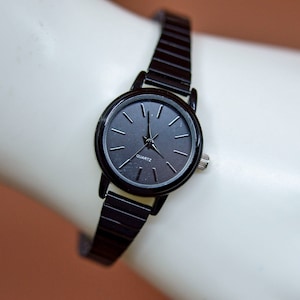 Black tone, womens, quartz wrist watch on stretch bracelet