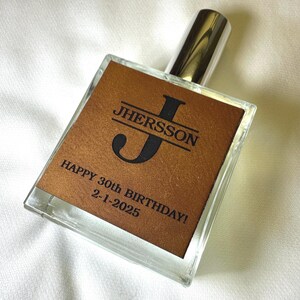 May include: A clear glass bottle with a brown leather label. The label has a large black letter "J" and the text "Jhersson Happy 30th Birthday! 2-1-2025".