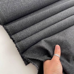 Wool in a deep graphite color. A fabric with high elasticity. Wrinkle-resistant fabric for coats, trousers, blazers, and skirts.