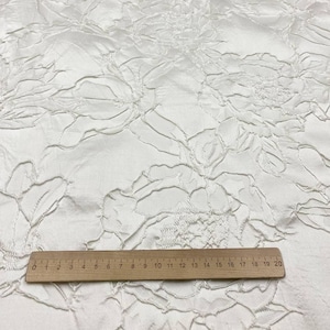 Thick ivory jacquard fabric with a raised floral pattern. A soft material perfect for wedding dresses, evening gowns, and bridal accessories