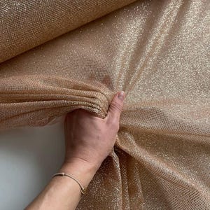 Tessuto scintillante con glitter. Materiale glitterato per abiti. Rete brillante ed elegante per abiti da ballo, vestiti da sera e accessori