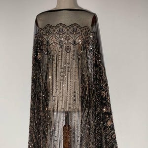 Lace densely decorated with sequins and beads. Floral and geometric motifs. Fabric that visually elongates the silhouette.