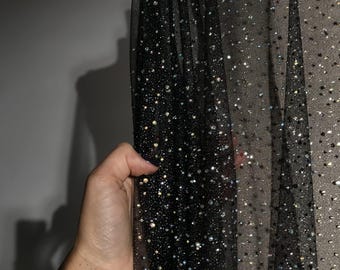 May include: Black sheer fabric with iridescent glitter dots.