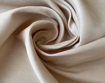 Natural silk in beige color. Lightweight matte fabric for elegant creations, suits, evening gowns, blouses, and chic accessories.