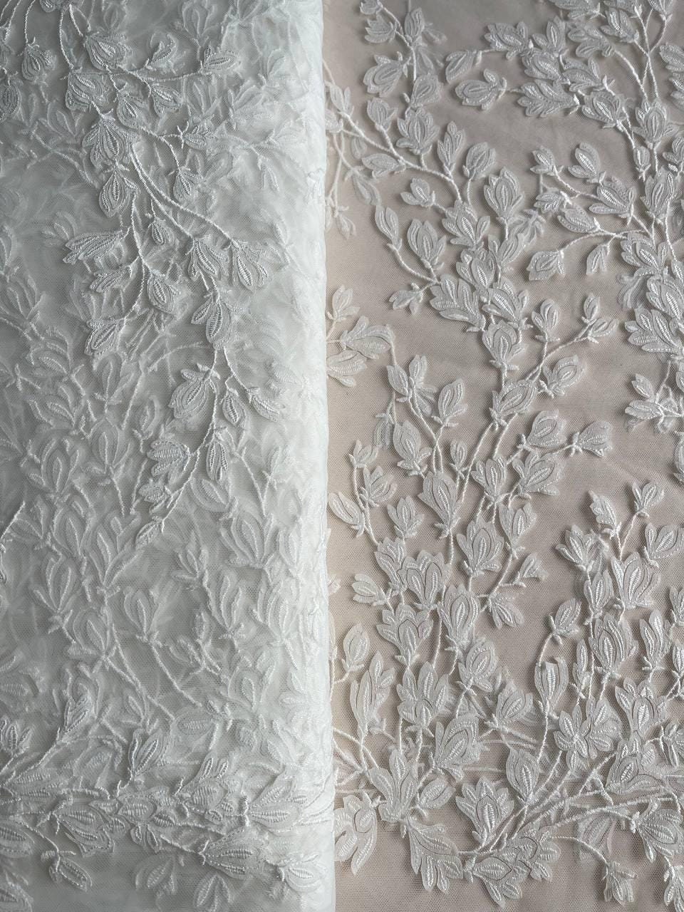 Zarte Brautspitze in gebrochenem Weiß, gefertigt auf weichem Netzstoff. Material mit 3D-Blumenmuster für Hochzeitskleider und Schleier.