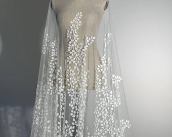 The wedding lace in off-white features a beautiful pattern of branches, carefully adorned with tiny 3D chiffon leaves.