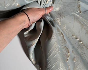 Jacquard mit dezent schimmerndem Muster großer Blätter. Auffälliger, weicher Stoff für Kleidung. Stoff mit Blättermotiv.