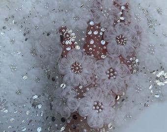 Lace adorned with flowers. The edges of the lace are densely decorated with sequins and pearls. Perfect for wedding dresses and accessories.