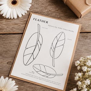 Pode incluir: Um padrão de papel branco intitulado FEATHER Pattern by Nikki Glass Works apresentando três desenhos de penas em linha preta com dimensões rotuladas como 2.5 x 7.5 in, 6 x 2 in e Mini 5 x 1.5 in, incluindo texto de direitos autorais na parte inferior.