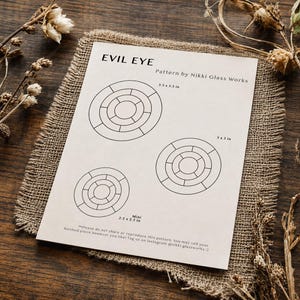 May include: A white paper pattern titled EVIL EYE by Nikki Glass Works featuring three circular designs with segment lines. The patterns are labelled with dimensions of 8.89 x 8.89 cm, 7.62 x 7.62 cm, and a mini version measuring 6.35 x 6.35 cm.
