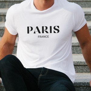 May include: A white t-shirt with the word "PARIS" in black lettering and the word "FRANCE" underneath.