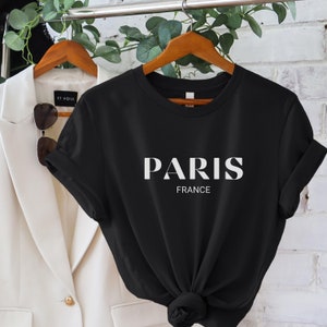 May include: Black t-shirt with white text that reads "PARIS FRANCE".