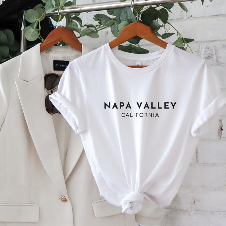 May include: White t-shirt with black text that reads "NAPA VALLEY CALIFORNIA"