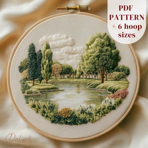 May include: A circular embroidery hoop containing a landscape scene stitched on off-white fabric. The design features a pond surrounded by various green trees, shrubs, and white clouds. Text in the upper right corner reads PDF PATTERN + 6 hoop sizes.