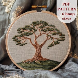 May include: Embroidered tree design in a wooden embroidery hoop. The tree features a brown trunk and branches with green foliage. The background is a light beige fabric. Text on the upper right reads "PDF PATTERN + 6 hoop sizes."