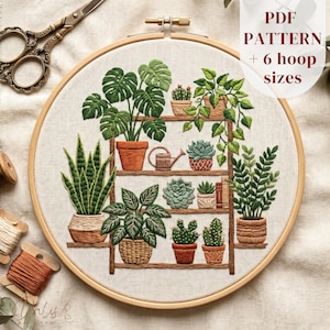 May include: An embroidery hoop containing a fabric panel with a stitched design of a wooden shelf holding various potted plants, including a monstera, snake plant, and succulents. The text PDF PATTERN + 6 hoop sizes is visible.