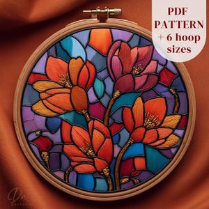 May include: A colorful embroidery hoop featuring a floral design with orange, red, purple, and teal hues. The embroidery resembles stained glass, with the text "PDF PATTERN + 6 hoop sizes" in the upper right corner. The hoop is made of wood.
