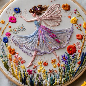 May include: Embroidered fairy hoop art. A fairy in a flowing blue, purple, and white dress with pink wings dances amidst colourful embroidered flowers. The artwork is set in a round, cream-coloured hoop, with the text "Dalis" visible.