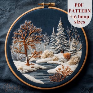 May include: Embroidered winter landscape in a wooden hoop. The design features a snow-covered scene with trees, a river, and a detailed, textured appearance. The text "PDF PATTERN + 6 hoop sizes" is visible.