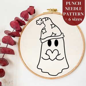 May include: A black and white line drawing of a ghost wearing a sleep cap and holding a heart. The ghost is in a wooden embroidery hoop.