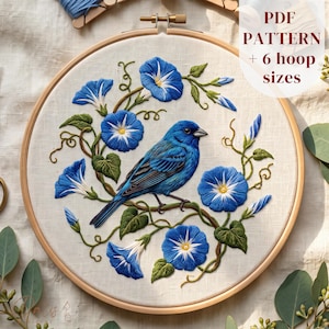 May include: An embroidery hoop containing a fabric panel with a stitched design of a blue bird perched on a vine surrounded by blue morning glory flowers and green leaves. The text PDF PATTERN + 6 hoop sizes is printed in the upper right corner.
