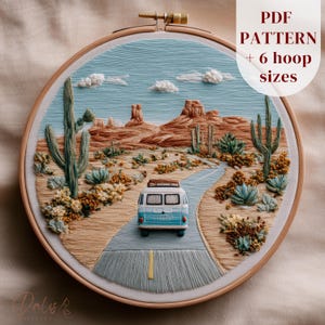 May include: An embroidery hoop containing a desert landscape scene with a blue and white van driving on a road. The scene features cacti, rock formations, and clouds. Text in the upper right corner reads: PDF PATTERN + 6 hoop sizes.