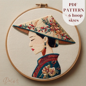 以下が含まれることがあります： 伝統的なアジアの帽子と衣装を身に着けた女性の横顔の刺繍フレーム。赤、ティール、ベージュの糸を使用。右上には「PDF PATTERN + 6 hoop sizes」の文字。