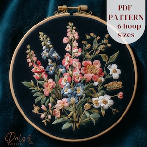 May include: An embroidered floral design in a wooden hoop. The artwork features a bouquet of pink, blue, and white flowers on a dark teal background. The text "PDF PATTERN + 6 hoop sizes" is visible. The artist's signature is at the bottom.