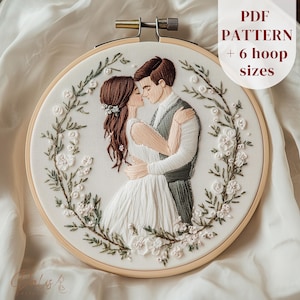 May include: Embroidered hoop art showing a couple embracing, framed by a floral wreath. The couple is depicted in a tender moment, with the text "PDF PATTERN + 6 hoop sizes" visible.