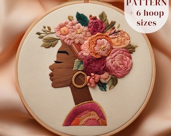 May include: An embroidery hoop featuring a profile of a woman with a floral headdress. The design uses shades of brown, pink, and orange. The text "PDF PATTERN + 6 hoop sizes" is displayed in a white oval. The hoop is made of wood.