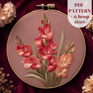 May include: An embroidery hoop featuring a detailed floral design of red and orange gladiolus flowers with green leaves. The text "PDF PATTERN + 6 hoop sizes" is displayed on the upper right. The hoop is set against a burgundy background.