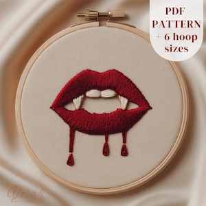 May include: Embroidery hoop featuring a red embroidered mouth with fangs and dripping blood. The text "PDF PATTERN + 6 hoop sizes" is in the upper right corner. The design is on a beige fabric.