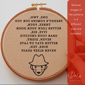 May include: A tan embroidery hoop with a stitched design featuring a detective face and text. The text is in reverse and includes phrases like "Never Sleep Again" and "One Two". The hoop is framed in a wooden ring.
