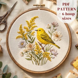 May include: An embroidery hoop containing a fabric panel with a stitched design of a bright yellow bird perched on a branch surrounded by yellow wildflowers and pale pink flowers. The text PDF PATTERN + 6 hoop sizes is visible in the corner.