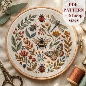 May include: A circular wooden embroidery hoop containing a linen fabric with a hand-stitched design of a bumblebee, butterfly, dragonfly, and two beetles surrounded by various botanical elements. Text on the image reads PDF PATTERN + 6 hoop sizes.