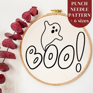 May include: A white embroidery hoop with a black line drawing of a ghost and the word "BOO!" in a playful font.