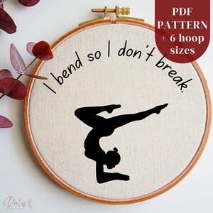 May include: A white embroidery hoop with a black silhouette of a woman in a yoga pose. The text "I bend so I don't break." is written around the silhouette.
