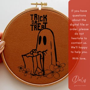 May include: A Halloween embroidery hoop with a ghost design and the words "TRICK OR TREAT". The black design is on burnt orange fabric, set in a wooden hoop. Floral accents are at the bottom. The text on the side is: "If you have questions..."