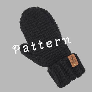 May include: Black knitted mitten with a brown leather patch that says "K Handmade by Keenness Craft Creations".