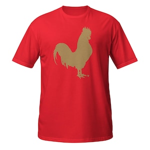 Op de afbeelding: Rood T-shirt met een gouden haan silhouet grafiek.