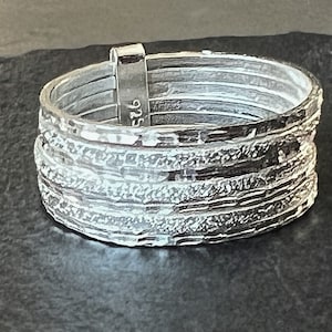 May include: Silver ring with a textured, layered design. The ring is marked with the number "526".
