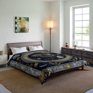 May include: A dark blue comforter with a celestial design featuring gold and silver accents. The comforter has a detailed pattern of stars, planets, and floral elements. The bed is made up with white pillows and a wooden bed frame.