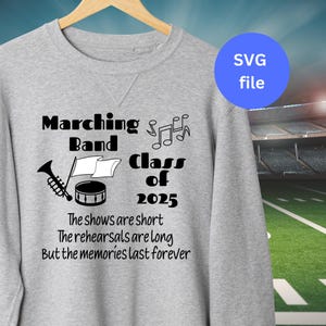 May include: A gray sweatshirt with a black design that says "Marching Band Class of 2025" with a trumpet, drum, and music notes. The text below says "The shows are short, The rehearsals are long, But the memories last forever."
