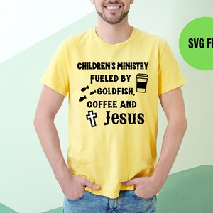 May include: A yellow t-shirt with the text "Children's Ministry Fueled by Goldfish, Coffee and Jesus" with a cross and a coffee cup graphic.