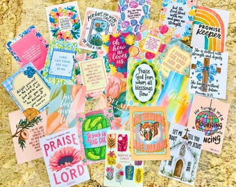 Op de afbeelding: Een verzameling rechthoekige kaarten met diverse kleurrijke illustraties en religieuze teksten, waaronder zinnen als Praise the Lord, Promise Keeper en Jesus is Big Dill, gerangschikt in een overlappende lay-out op een gestructureerd oppervlak.